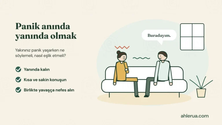 Kanepede oturan iki yetişkin: başının üstünde gerginlik çizgisi olan, gözleri kapalı, eli göğsünde bir kadın ve yanında sakin oturup “Buradayım.” diyen bir erkek; aralarında sakin bir dalga çizgisi. Solda “Panik anında yanında olmak” başlığı ve yeşil onay işaretli üç öneri: Yanında kalın, kısa ve sakin konuşun, birlikte yavaşça nefes alın.